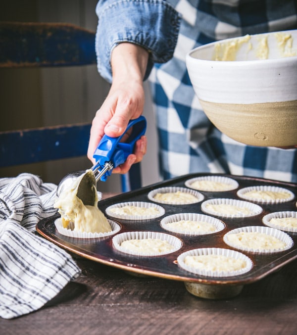 Scoop putting batter in a muffin tin