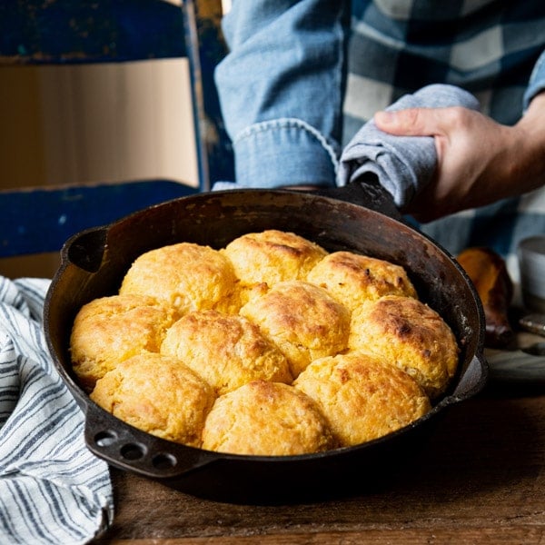 Hands holding a skillet full of the best sweet potato biscuit recipe