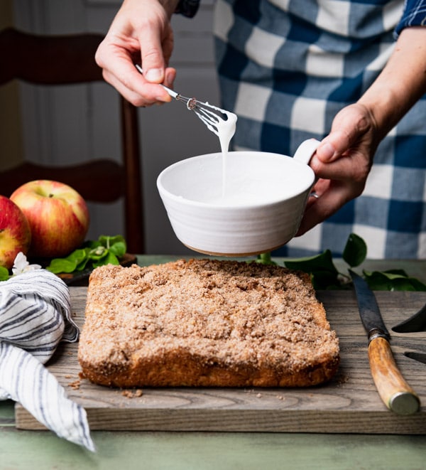 Whisking together powdered sugar glaze in a white bowl  Easy Apple Espresso Cake apple coffee cake 5