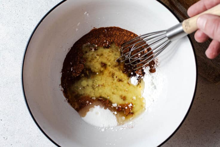 Ingredients for baked apple slices in a mixing bowl.