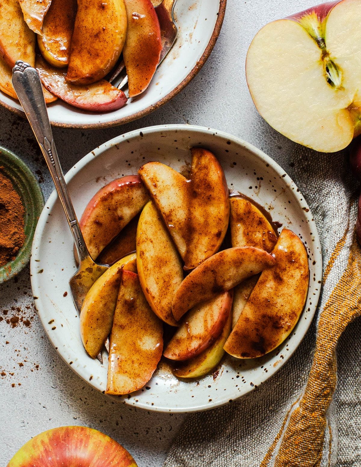 Bowl of baked apple slices with cinnamon and sugar.