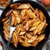 Square overhead shot of baked apple slices in a cast iron skillet.