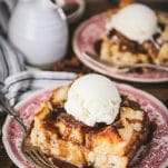 Close up shot of the best bread pudding recipe served with bourbon sauce and vanilla ice cream.
