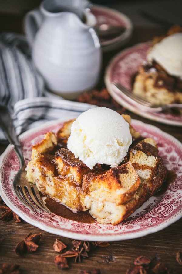 Big slice of Southern bread pudding with bourbon sauce and vanilla ice cream on a plate.