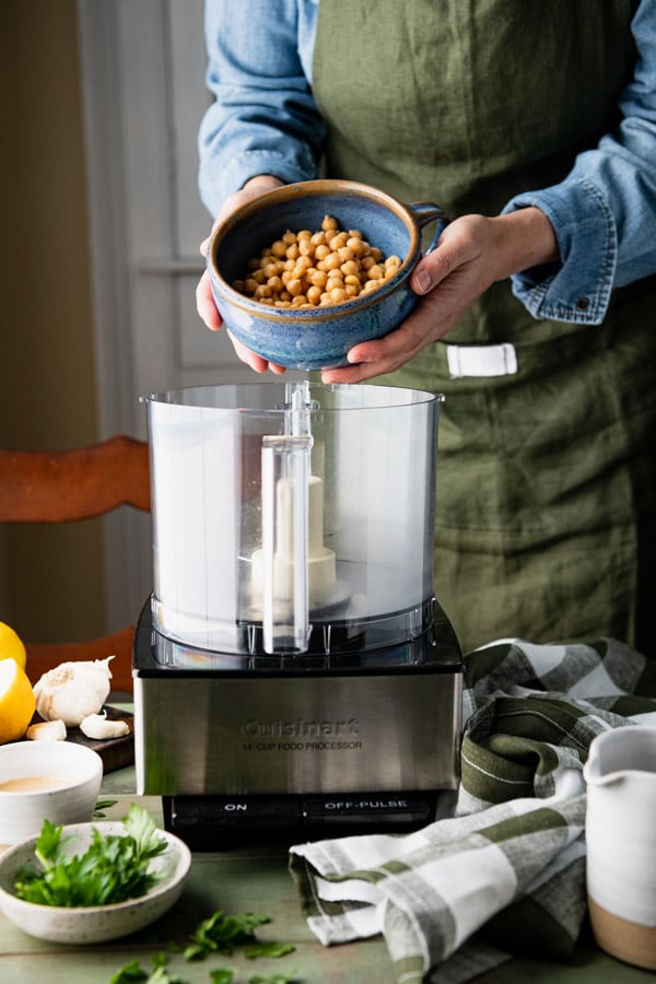 Bowl of canned chickpeas over a food processor
