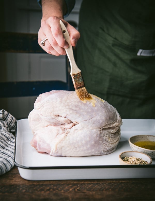 Brushing turkey breast with olive oil
