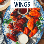 Overhead shot of a blue and white tray full of baked chicken wings with text title overlay