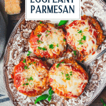 Close overhead image of a platter of the best baked eggplant parmesan recipe with text title overlay