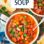 Overhead image of a spoon in a bowl of ham and bean soup with text title overlay