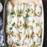 Overhead shot of creamy chicken stuffed shells in a blue baking dish on a table