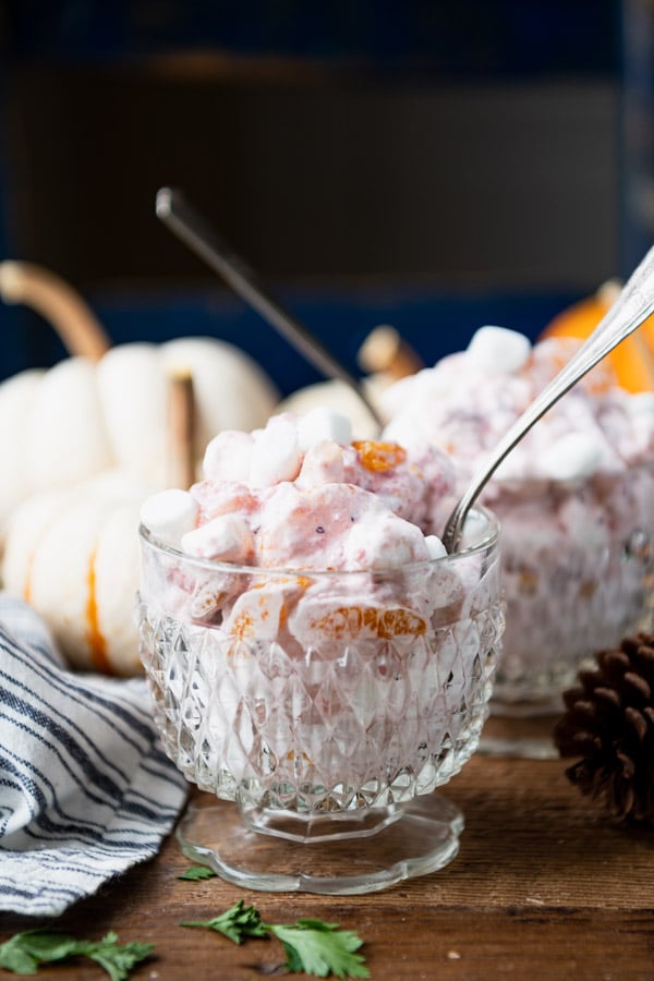 Two glass dishes of cranberry fluff with spoons