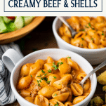 Side shot of a bowl of creamy beef and shells with text title box at top
