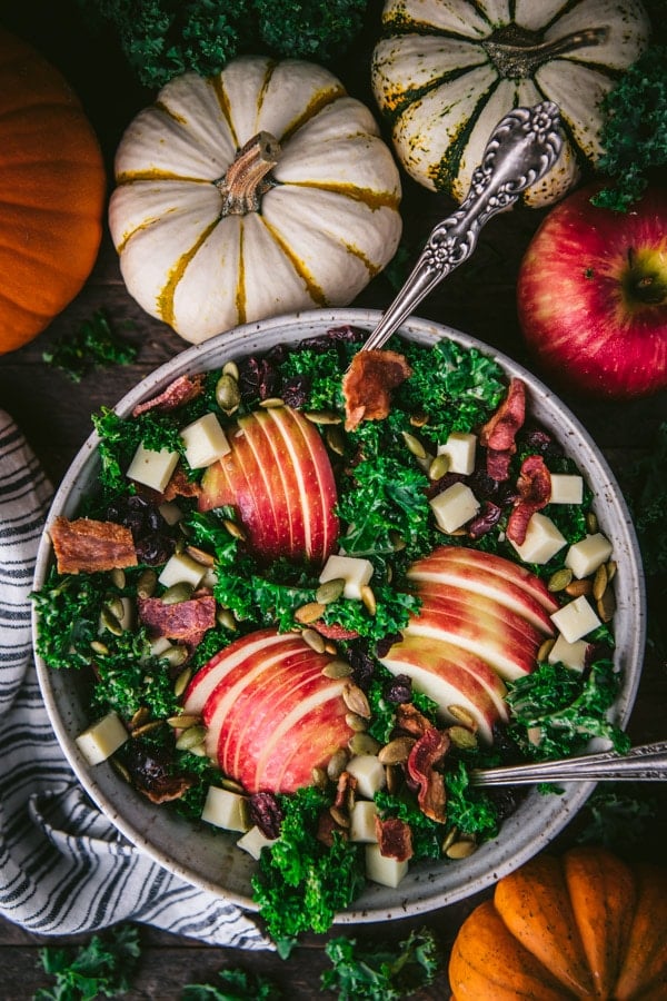 Overhead shot of fall salad with serving spoons in a bowl