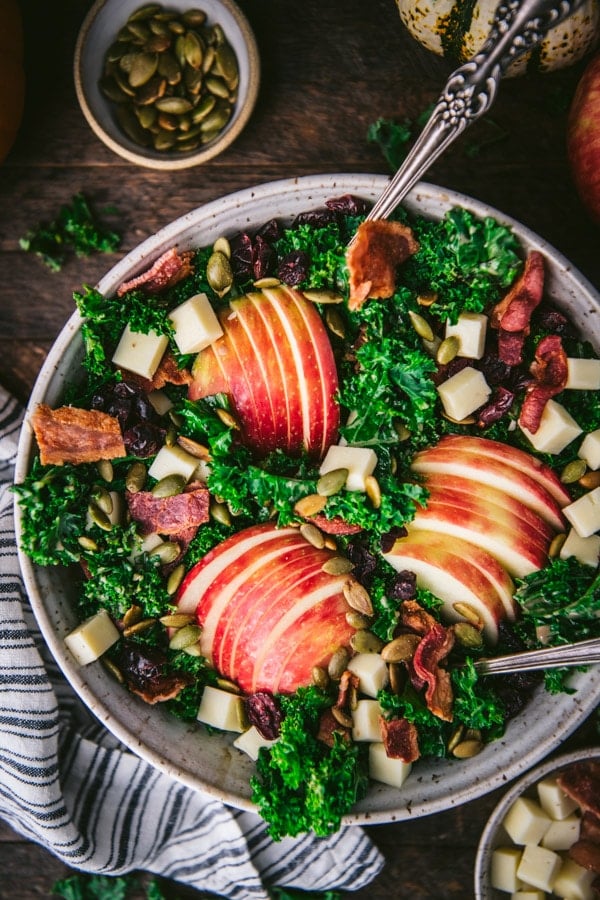 Apples and bacon on a fall salad in a white bowl