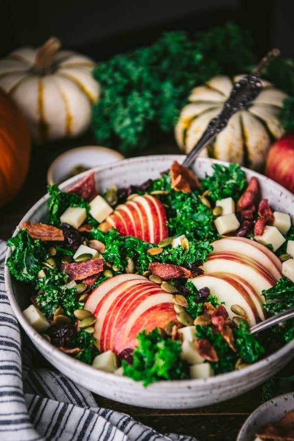 Close up side shot of a kale salad with apples and other fall ingredients