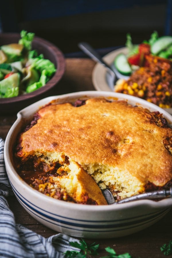 Ground beef and cornbread casserole in a baking dish on a table