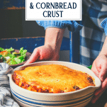 Hands holding a ground beef casserole with text title overlay