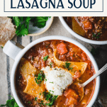 Close overhead image of a bowl of easy lasagna soup recipe topped with ricotta cheese