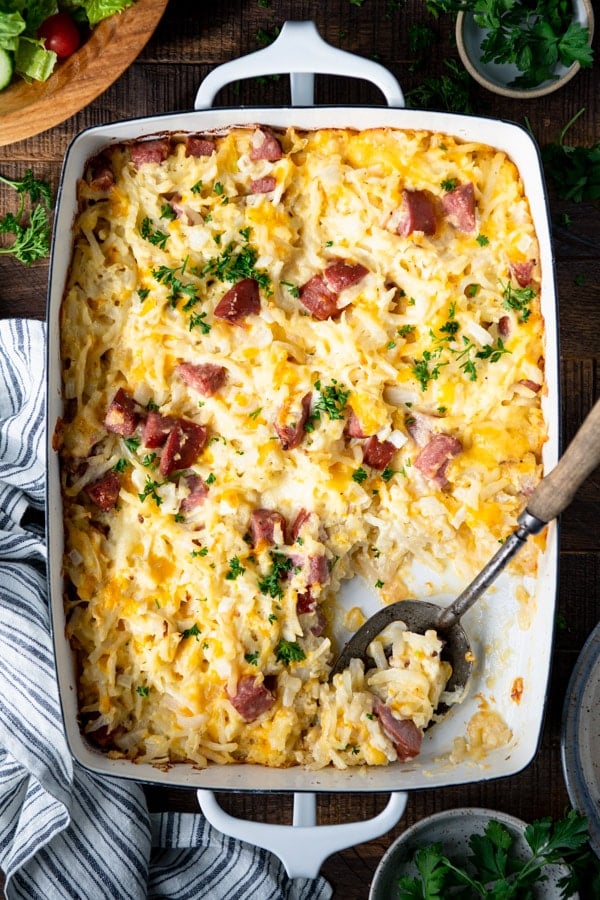 Overhead image of hash brown sausage casserole with a serving spoon