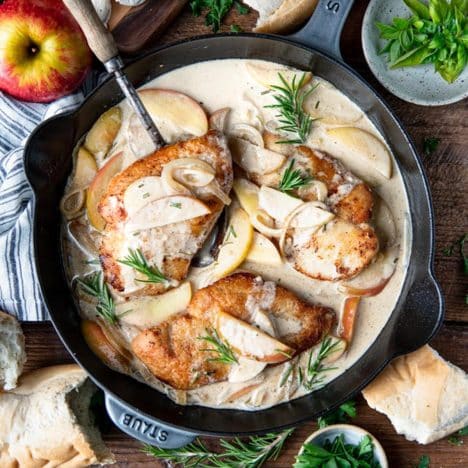 Square overhead shot of skillet chicken with apples and onions.