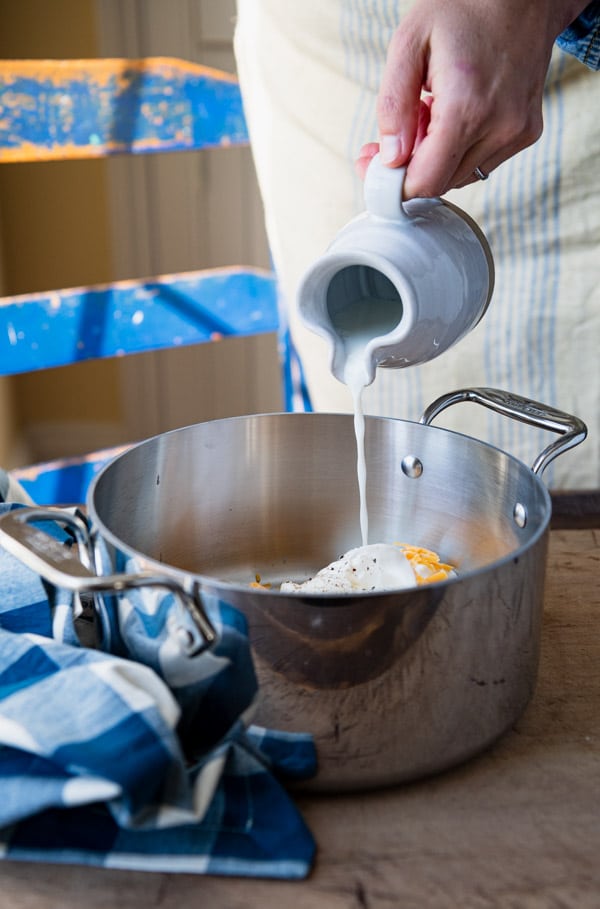 Pouring milk into a saucepan.