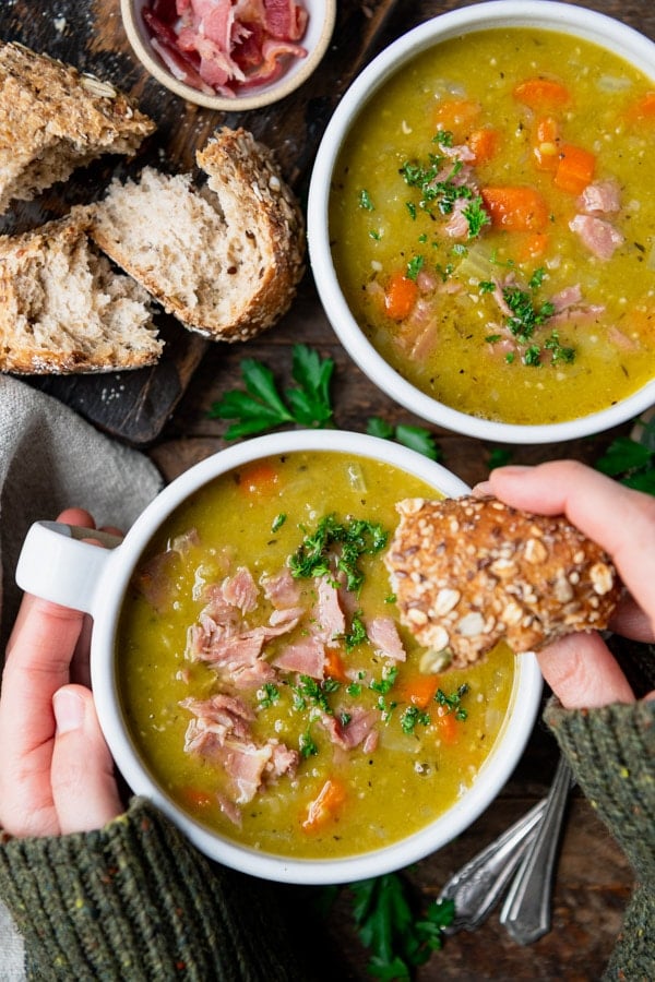 Dipping bread in a bowl of Instant Pot split pea soup.