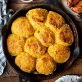 Square overhead shot of sweet potato biscuits in a cast iron skillet.