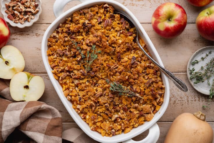 Horizontal overhead shot of butternut squash casserole with apples in a white baking dish.