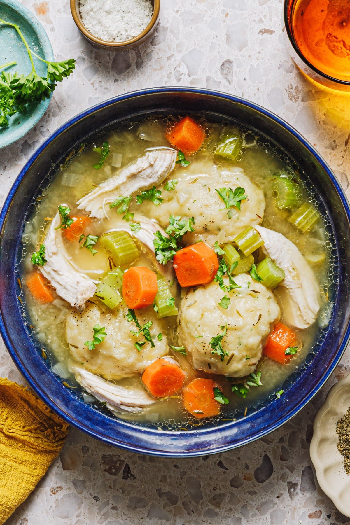 Overhead shot of a blue bowl full of homemade chicken and dumpling soup.