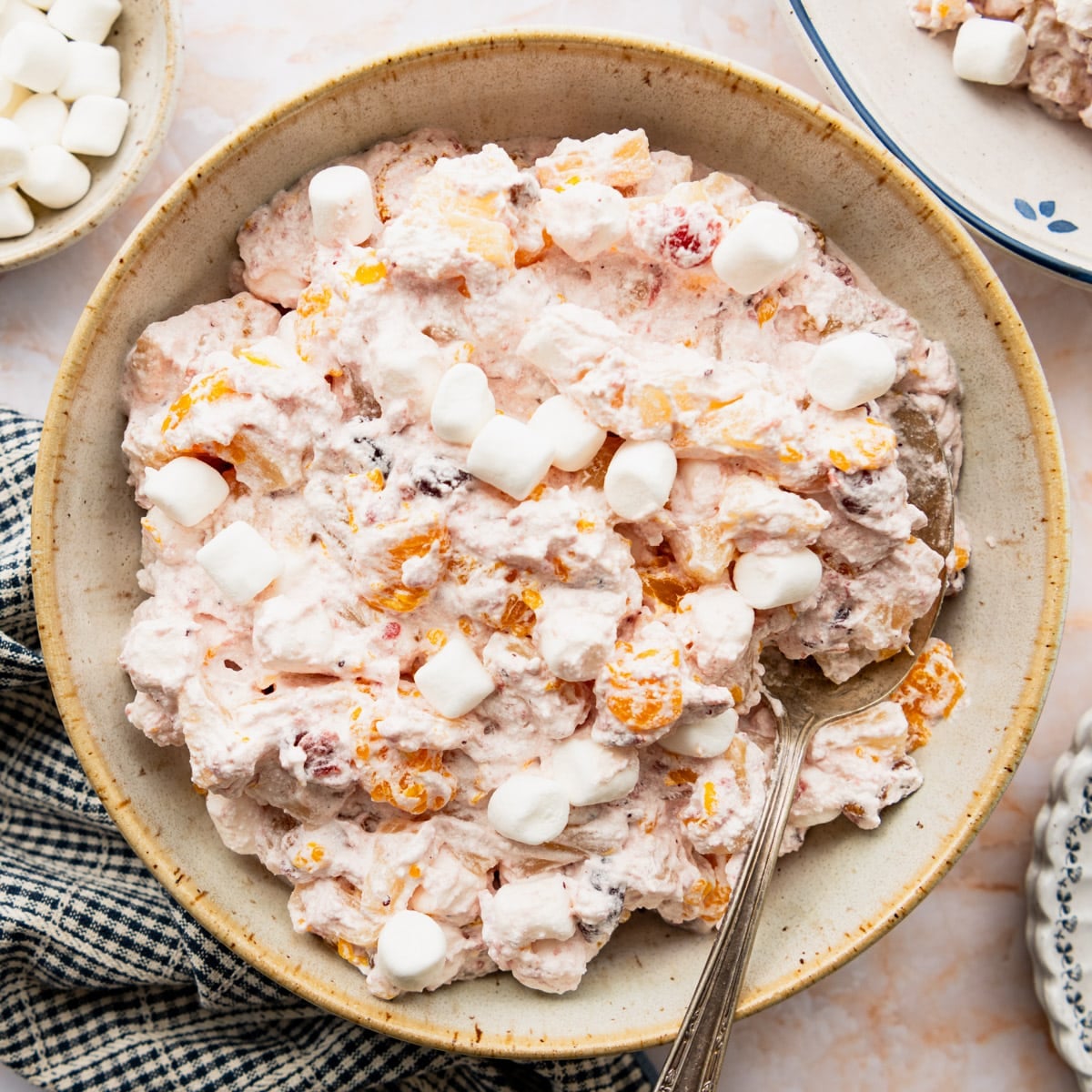 Square overhead image of cranberry fluff salad in a serving bowl with extra marshmallows on top for garnish.