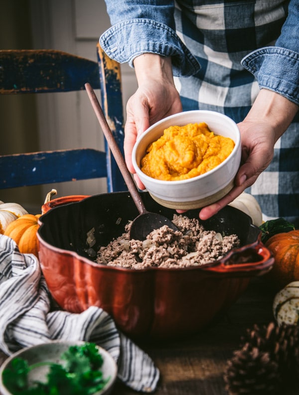 Adding pumpkin puree to a pot