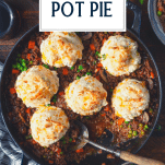 Overhead shot of a serving spoon in a pan of beef pot pie with text title overlay.