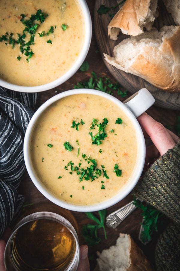 Overhead shot of hands holding a bowl of easy broccoli cheese soup.