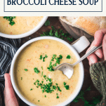Overhead image of hands eating from a bowl of broccoli cheese soup with text title box at top.