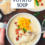 Hands eating bowl of crock pot potato soup with text title overlay