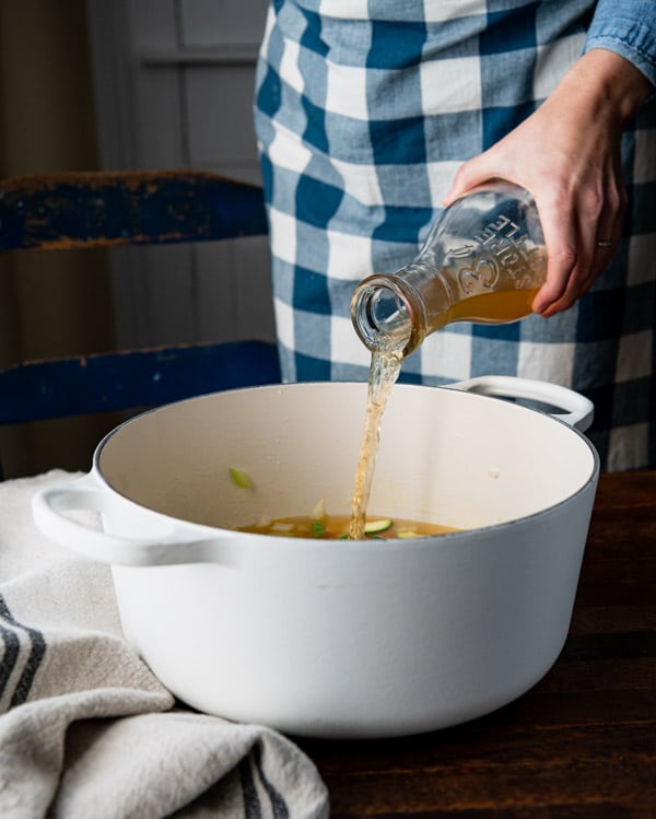 Pouring broth into a pot.