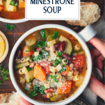 Overhead shot of hands holding a bowl of easy minestrone soup with text title overlay