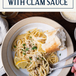 Close overhead shot of a bowl of linguine with clam sauce and text title box at top.
