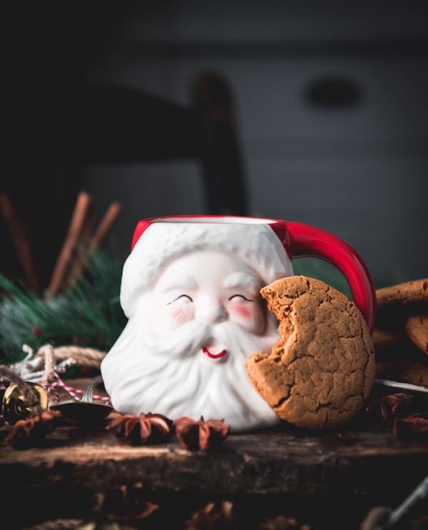 Side shot of a Santa mug with gingerbread cookies.