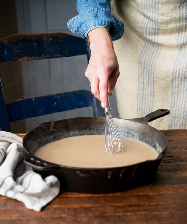 Batir la salsa sueca de albóndigas en una sartén de hierro fundido