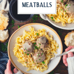Overhead shot of hands eating Swedish meatballs in a bowl with text title overlay