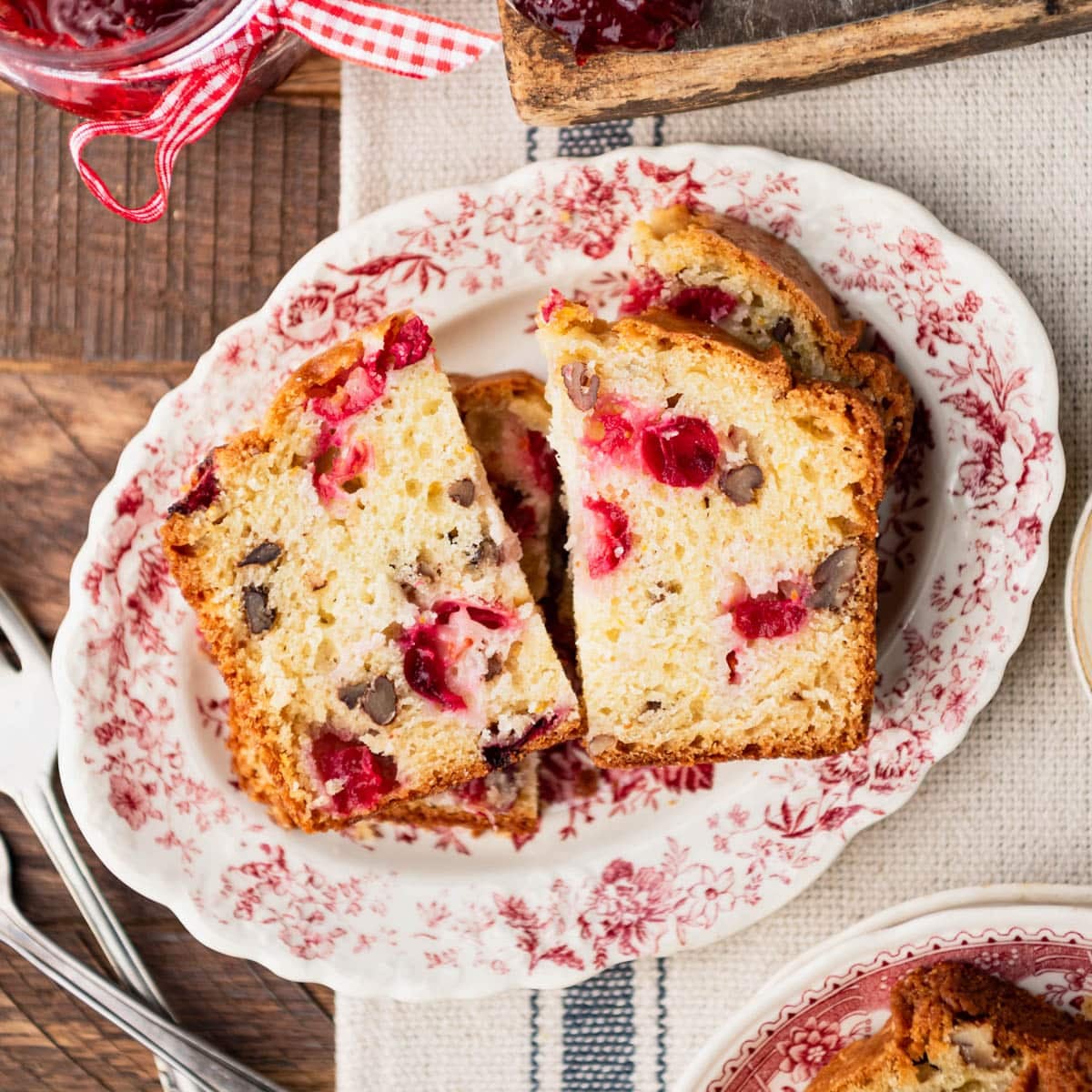 Square overhead shot of cranberry bread slices served on a red and white platter.