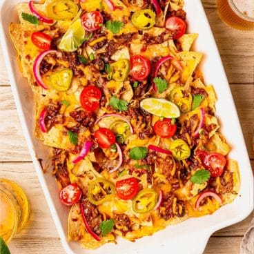 Square overhead shot of a pan of pulled pork nachos.