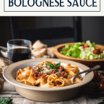 Side shot of easy bolognese sauce over noodles with text title box at top.
