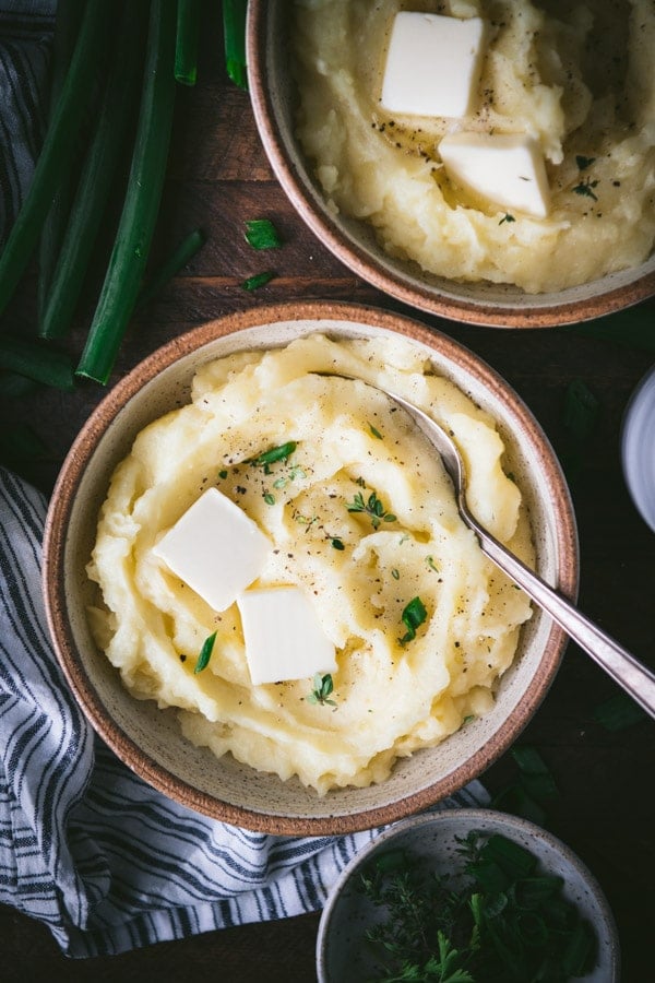 Overhead shot of creamy mashed potatoes on a dinner table.