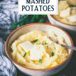 Side shot of a bowl of buttermilk mashed potatoes with text title overlay.