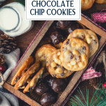 Overhead shot of a wooden box full of cranberry and white chocolate chip cookies with text title overlay