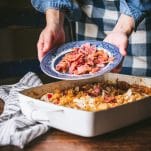 Adding bacon to the top of a casserole.