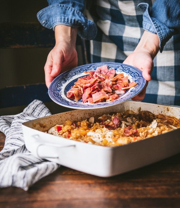 Adding bacon to the top of a casserole.
