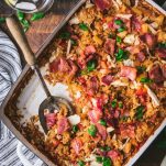 Overhead image of a white baking dish full of baked chicken and rice casserole with bacon and pineapple.